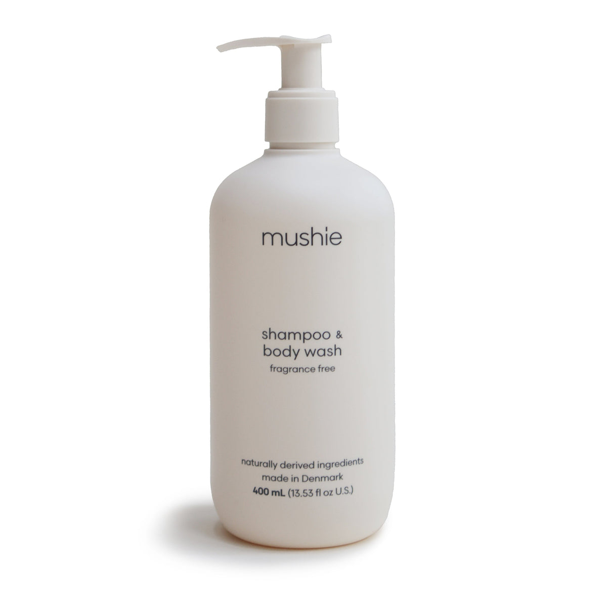 A white pump bottle labeled mushie Fragrance Free Baby Shampoo & Body Wash contains 400 ml of gentle, naturally derived formula made in Denmark.