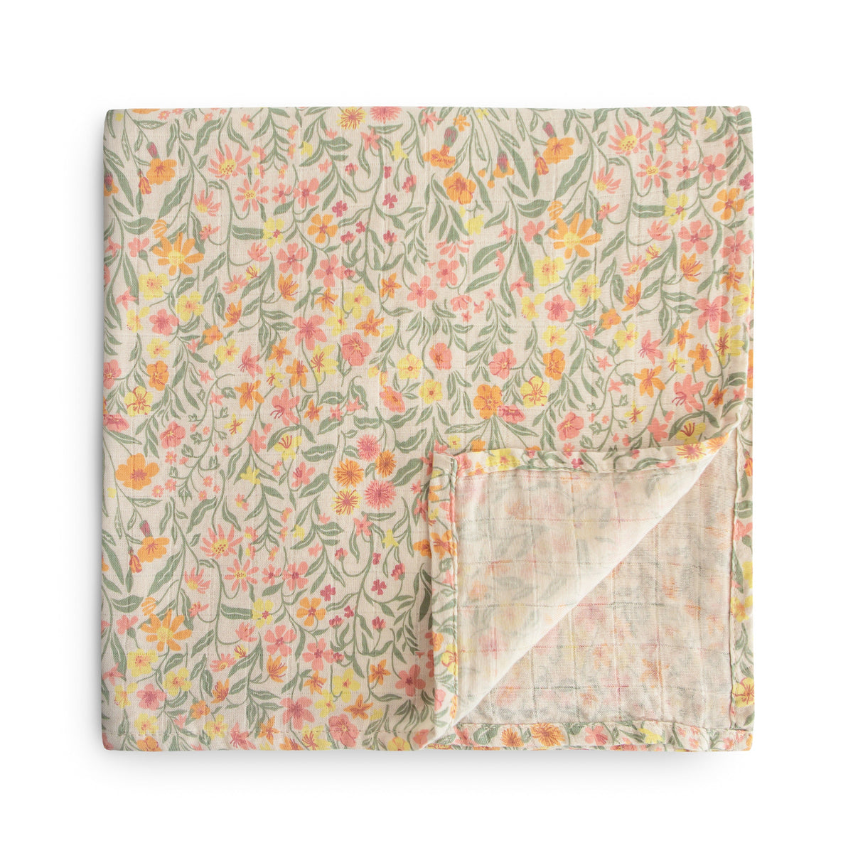 The mushie Organic Cotton Muslin Swaddle Blanket in Pastel Blooms, featuring a soft floral pattern, is shown folded with one corner turned up to reveal the reverse side.